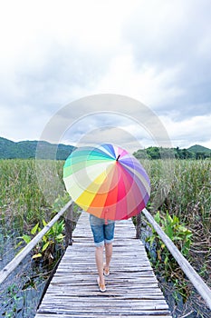 Woman holding an umbrella on the bridge.
