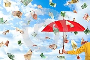 Woman holding umbrella under money rain and sky on background, closeup