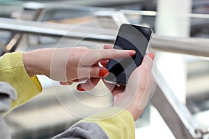 Woman holding and using the mobile smart phone