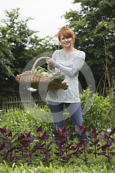 Woman Holding Vegetable Basket In Garden