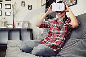 Woman holding virtual reality headset glasses and smiling