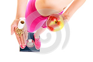 Woman holding vitamins and apple. Health care.