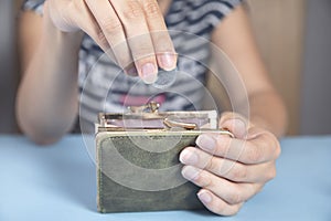 Woman holding wallet and coins