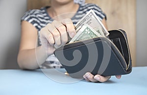 Woman holding wallet and money
