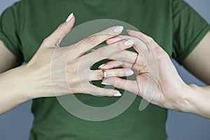 A woman is holding a wedding ring. Concept of love, family. Upset girl holding wedding ring, depressed due to divorce