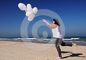Woman holding white balloons