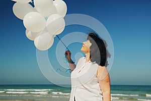 Woman holding white balloons