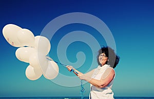 Woman holding white balloons