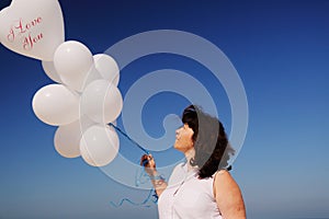 Woman holding white balloons