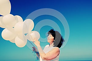 Woman holding white balloons