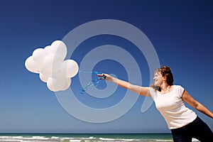 Woman holding white balloons