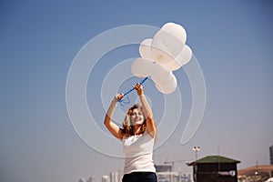 Woman holding white balloons