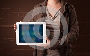 Woman holding a white tablet with blurry apps