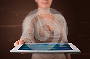 Woman holding a white tablet with blurry apps