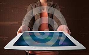 Woman holding a white tablet with blurry apps