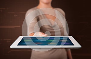 Woman holding a white tablet with blurry apps