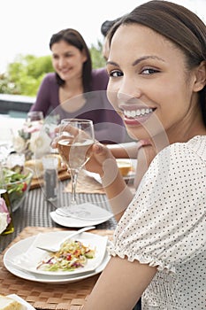 Woman Holding Wineglass At Dinner Party