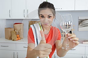 woman holding wineglass and making thumbs up gesture