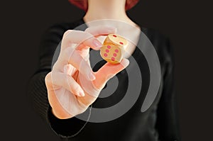 woman holding wooden dice in her hand, isolated on black background. Concept chance, luck, fortune