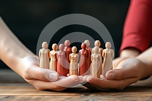 Woman holding wooden figures of people on table, closeup. Teamwork concept