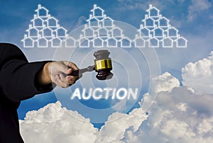 Woman holding a wooden hammer in a suit pointing out to the bidders, and a house icon on a sky background, With concept