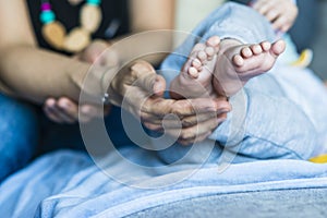A woman holds a baby`s little feet
