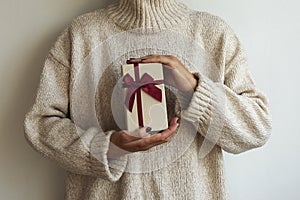 Woman holds a beautiful gift box with red bow in her hand. Christmas, New Year, Valentine& x27;s day, Women& x27;s day holiday