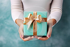 A woman holds a beautifully wrapped gift box. The focus on the gift symbolizes appreciation, thoughtfulness