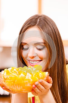 Woman holds bowl full of sliced orange fruits