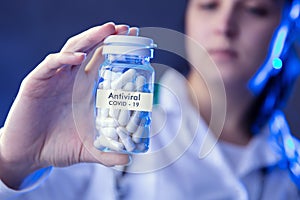 Woman holds box of antiviral medicines