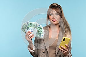 Woman holds bunch dollars and phone