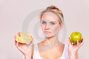 Woman holds cake and fruit in hand choosing