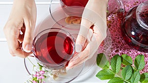 A woman holds a Cup of tea. Red tea, hibiscus, karkade, Rooibos. Ceremony, afternoon tea, Breakfast. Tea time, carcade. Oriental,