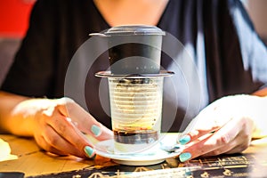 Woman holds cup of Vietnamese coffee. Defocused