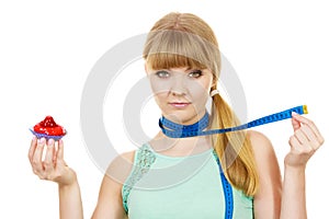 Woman holds cupcake trying to resist temptation