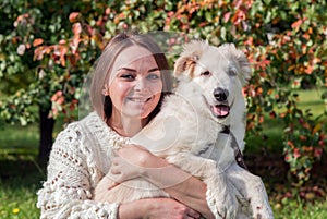 Woman holds the dog in city park