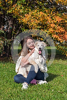 Woman holds the dog in city park