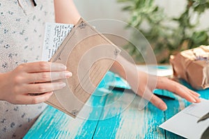 A woman holds an empty envelope with a letter in her hand. Hands close-up. The concept of a mail message and postcrossing