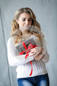 Woman holds a gift in a box on a birthday or new year