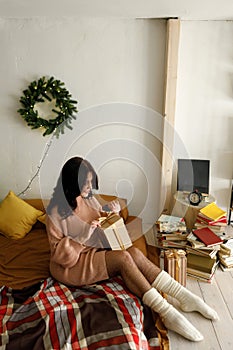 Woman holds gift in her hands and unties ribbon