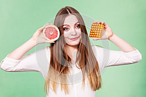 Woman holds grapefruit and pills blister pack vitamin c