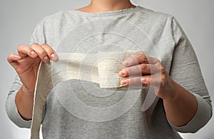 Woman holds in hand a white elastic bandage for the body