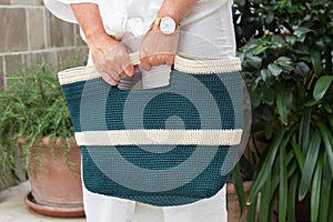 Woman holds a handmade blue knitted bag outdoors. Sustainable shopping. Wasteless lifestyle