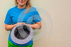 Woman holds a hat and asks help. White girl stays and begs money or panhandling. Front portrait with half part face. Copy space is