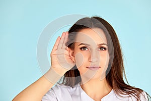 Woman holds her hand near ear and listens carefully