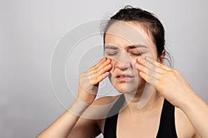 The woman holds her hands on the face - pain in sinuses, sinusitis perch and sinusitis, antritis, headache. With a place