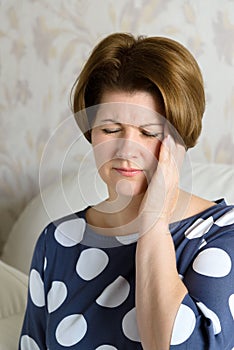 Woman holds her head with a migraine attack