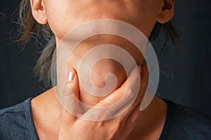 Woman holds her throat, sore throat