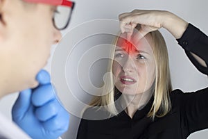 A woman holds his head with his hands. Sensation of headache, migraine and dizziness. Headaches from stress or overwork. On