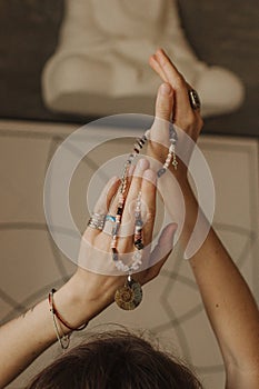 Woman holds jewelry made of natural stones in her hand, her hands are decorated with rings and bracelets. Handicrafts and